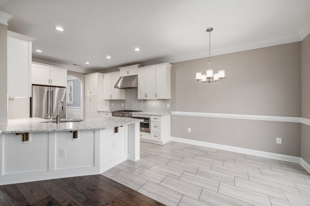 Bright modern kitchen with granite island and stainless steel appliances.
